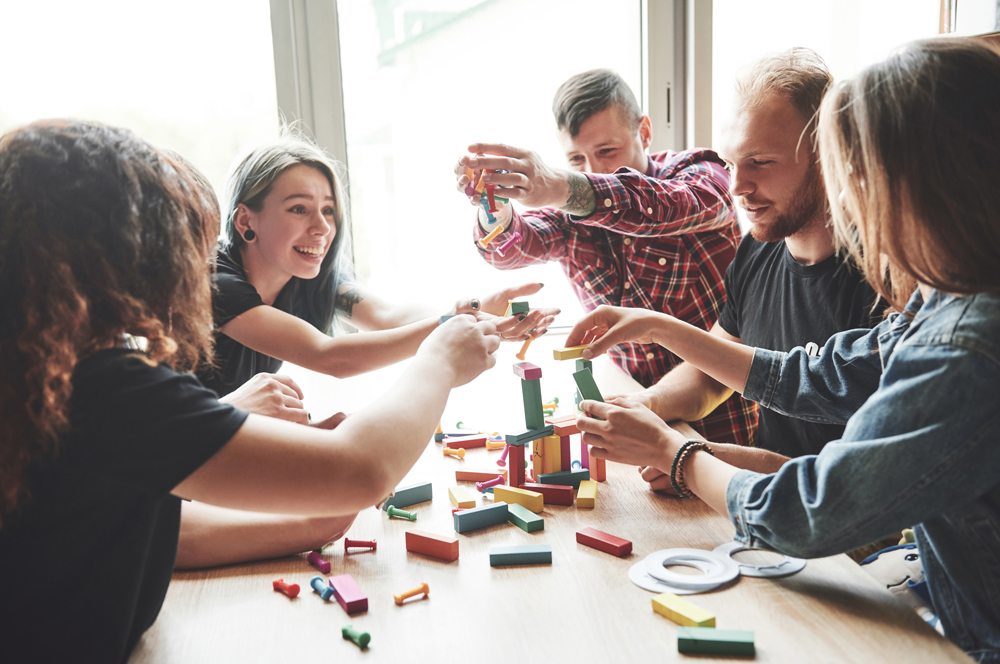 a-group-of-creative-friends-sitting-on-a-wooden-table-people-were-having-fun-while-playing-a-board-game-web
