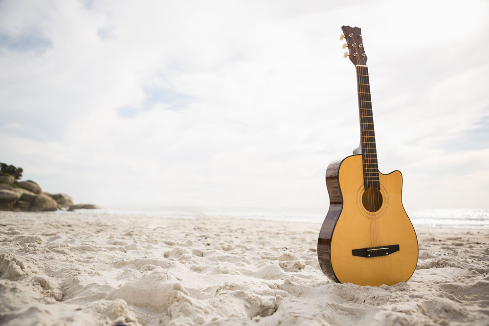 acoustic-guitar-standing-in-the-sandweb
