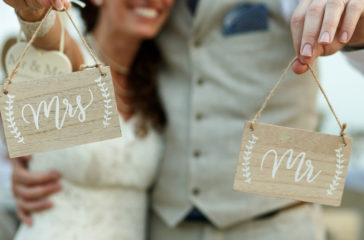 happy-newlyweds-hold-wooden-boards-with-letterings-mrs-mr-web